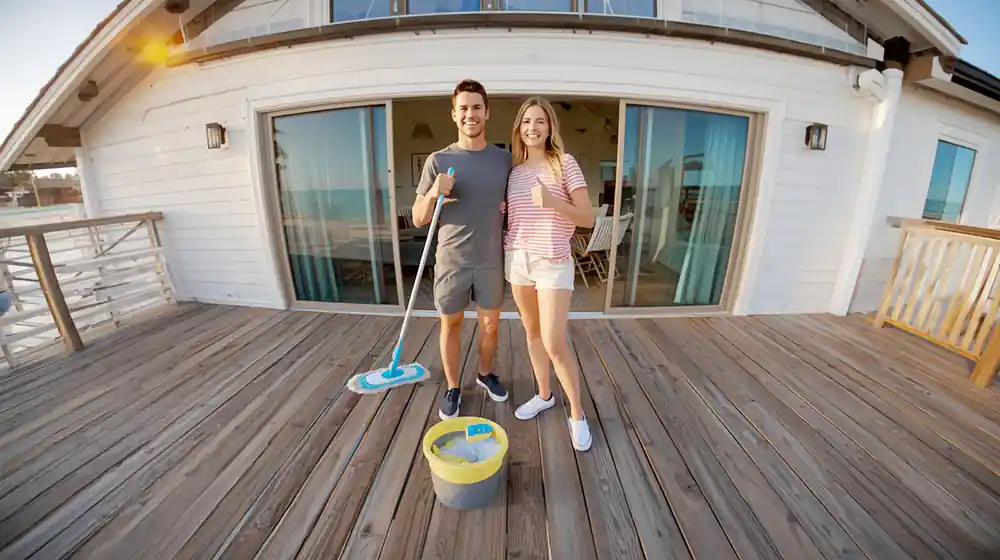 Hombre limpiando tarima sintética de exterior